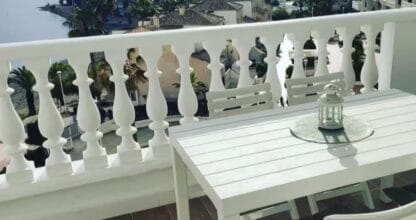 Terraza exterior con mesa y banco blancos en Apartamento dos mares con vistas panorámicas al Mar Menor desde las alturas