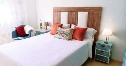 Dormitorio de Apartamentos Hondahouse con cama doble, cabecero de madera y mesitas vintage