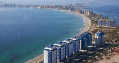 Vista aérea de los Apartamentos Mar Azul con edificios de fachada azul frente a la playa de La Manga del Mar Menor