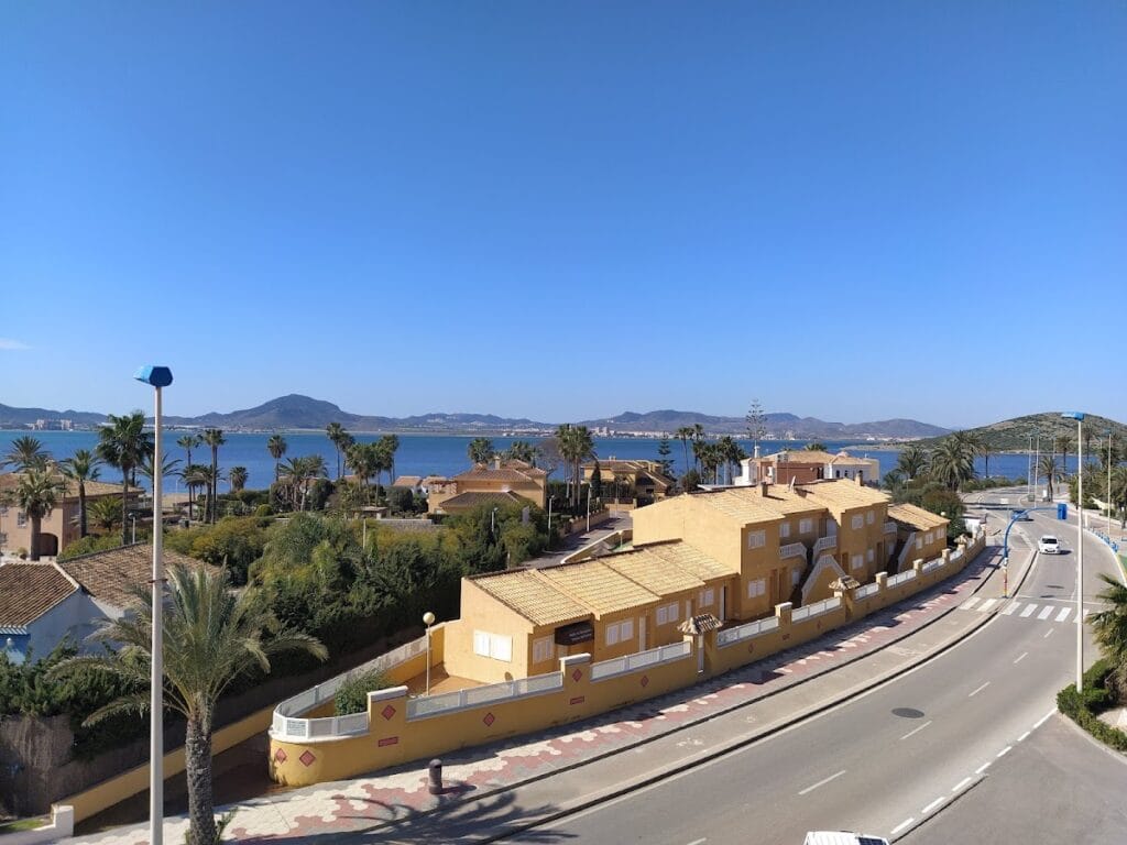 Vista aérea de Apartamentos Olympia Center en La Manga del Mar Menor con vistas al mar y montañas al fondo