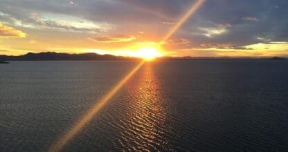 Espectacular puesta de sol sobre el Mar Menor con reflejo dorado en el agua visto desde La Manga