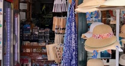 Entrada de Arpon-2 Souvenirs y Papelería en La Manga del Mar Menor con sombreros de paja, pareos y artículos de playa expuestos al exterior