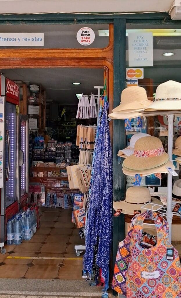 Entrada de Arpon-2 Souvenirs y Papelería en La Manga del Mar Menor con sombreros de paja, pareos y artículos de playa expuestos al exterior