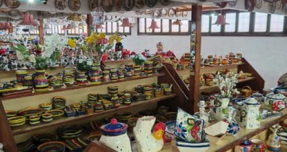 Interior de Arte Cerámico Cabo de Palos con estanterías llenas de platos, jarras y piezas de cerámica pintada