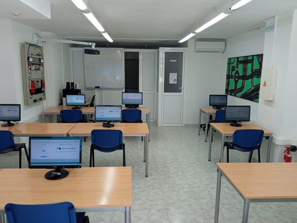 Aula de teoría de Autoescuelas San Nicolás en La Manga con ordenadores, pizarra blanca y proyector para preparar el carnet de conducir