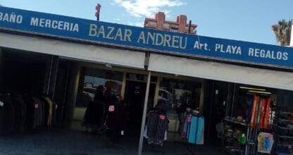 Fachada del Bazar Andréu en La Manga del Mar Menor con artículos de playa, ropa y regalos expuestos bajo cartel azul