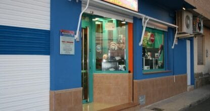 Fachada azul de la tienda de informática Belotecno con escaparate de accesorios y gadgets electrónicos, La Manga del Mar Menor