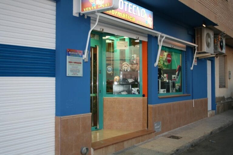 Fachada azul de la tienda de informática Belotecno con escaparate de accesorios y gadgets electrónicos, La Manga del Mar Menor
