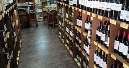 Interior de Bodega La Ermita con largas estanterías repletas de botellas de vino en La Manga del Mar Menor