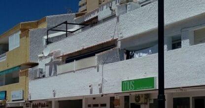 Fachada de Boutique MUS con rótulo verde en zona comercial peatonal de La Manga del Mar Menor bajo cielo azul
