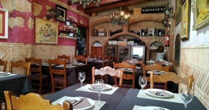 Interior rústico de Brasería Garnacha con arcos de ladrillo, bodega y mesas preparadas en Los Belones, La Manga