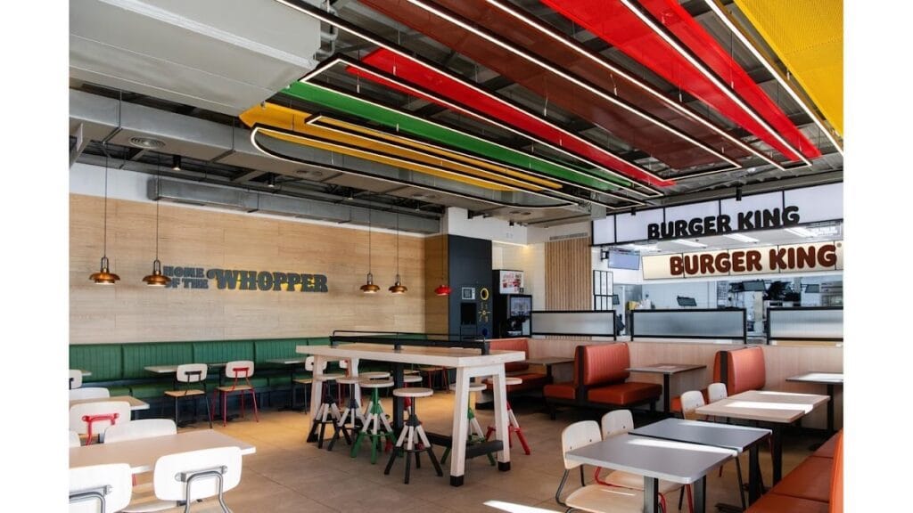 Interior moderno de Burger King en La Manga del Mar Menor con decoración colorida en el techo, cabinas y zona de mostrador