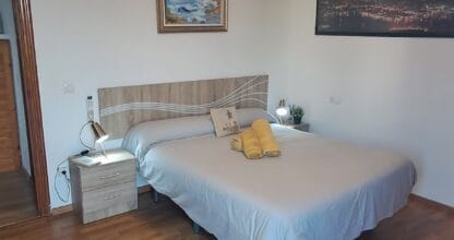 Habitación de matrimonio amplia en alojamiento vacacional Cabo de Palos con suelo de parqué y cuadros decorativos en pared