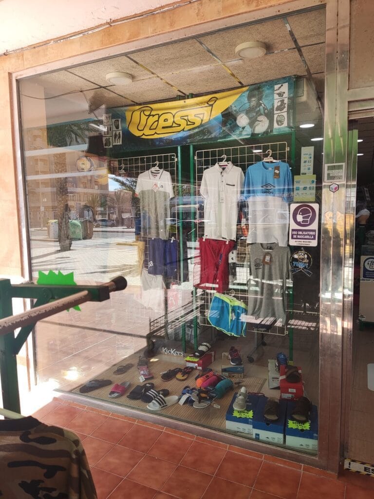 Escaparate de Cachucha's Sportif con camisetas, pantalones deportivos y calzado expuesto en La Manga del Mar Menor