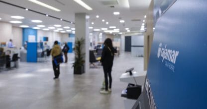 Interior moderno de oficina Cajamar Caja Rural con clientes atendidos por empleados en espacio diáfano azul y blanco