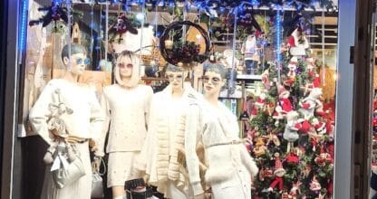 Escaparate navideño de Casa JC en La Manga del Mar Menor con maniquíes en ropa blanca, árbol de Navidad y decoración festiva