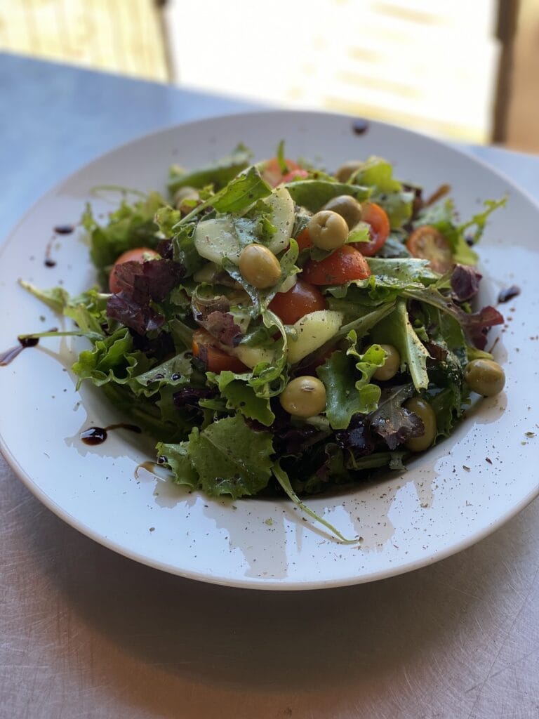 Ensalada fresca del Chiringuito Odesa Beach con lechuga variada, tomates cherry, garbanzos y reducción de balsámico