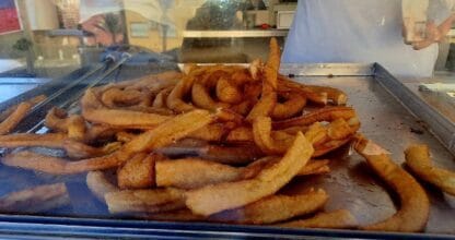 Bandeja de churros recién fritos en la Churrería A Por Churros de La Manga del Mar Menor, vistos a través del cristal