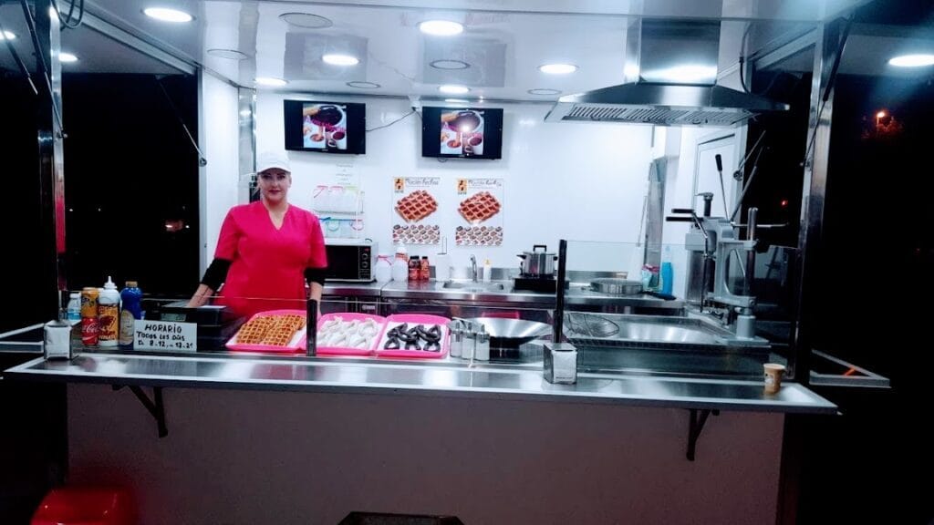 Puesto nocturno de Chocochurros con churros, gofres y trabajadora en uniforme rosa, La Manga del Mar Menor