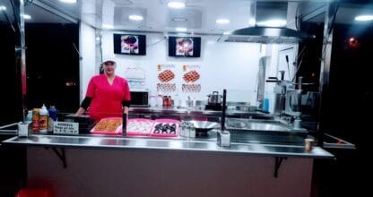 Puesto nocturno de Chocochurros con churros, gofres y trabajadora en uniforme rosa, La Manga del Mar Menor