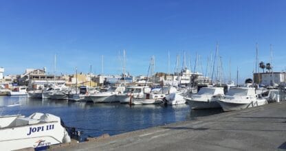 Puerto deportivo del Club Náutico Cabo de Palos con veleros y embarcaciones amarradas junto al paseo marítimo en día soleado