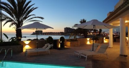 Terraza con piscina iluminada al atardecer y vistas al mar en Colina del Emperador, alojamiento en La Manga del Mar Menor