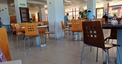 Amplio comedor del ApartHotel Londres en La Manga con mesas y sillas de madera para el servicio de buffet