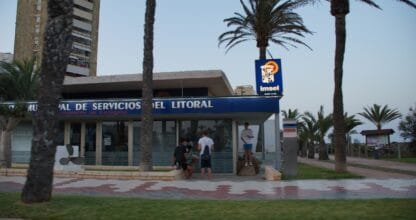 Edificio del IMSEL Instituto Municipal de Servicios del Litoral con palmeras y jóvenes en la entrada en La Manga del Mar Menor