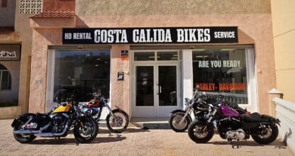 Fachada de Costa Calida Bikes con cuatro motos Harley-Davidson aparcadas en la puerta, alquiler de motos en La Manga del Mar Menor