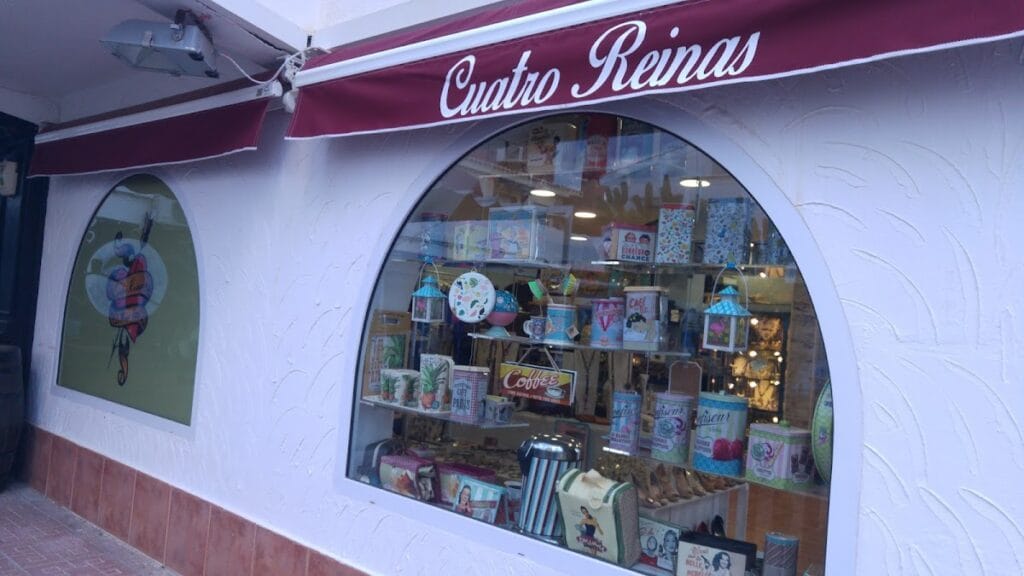 Escaparate de Cuatro Reinas con artículos de regalo y decoración vintage bajo toldo burdeos en La Manga del Mar Menor