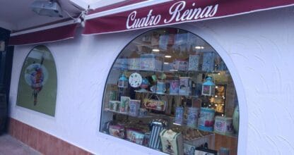 Escaparate de Cuatro Reinas con artículos de regalo y decoración vintage bajo toldo burdeos en La Manga del Mar Menor