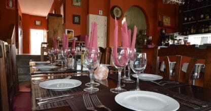 Interior de Dante's Pizzeria Steak-House en La Manga del Mar Menor con mesas de madera oscura preparadas, servilletas rosas dobladas y copas de vino