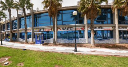 Edificio comercial acristalado con palmeras y locales de moda en D'Costa Puerto y Playa, La Manga del Mar Menor