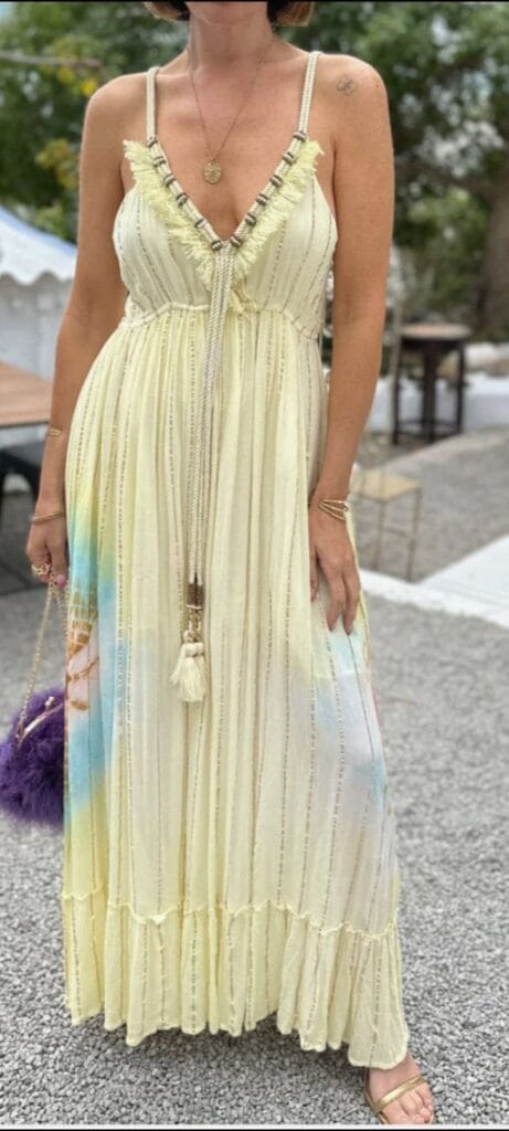 Modelo luciendo vestido largo maxi de verano en tonos crema y tie-dye con flecos, disponible en De' moda La Manga del Mar Menor