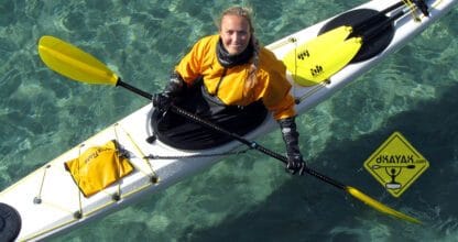 Monitora de DKAYAK sonriendo a bordo de kayak amarillo sobre aguas cristalinas turquesas de Cabo de Palos