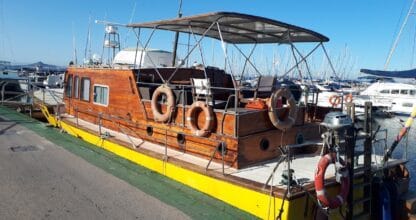 Barco de madera vintage con aros salvavidas amarrado en el puerto del Club Náutico Los Nietos, La Manga