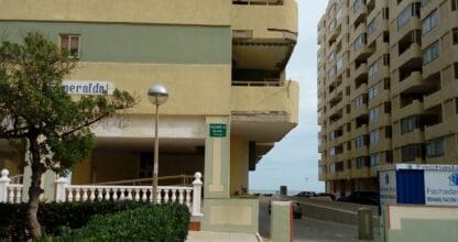 Exterior del edificio Esmeralda III en La Manga del Mar Menor con acceso peatonal, jardín y acceso a playa señalizado