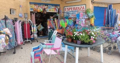 Tienda Esperanza con ropa, sillas de playa, flores y artículos variados expuestos en la acera, La Manga