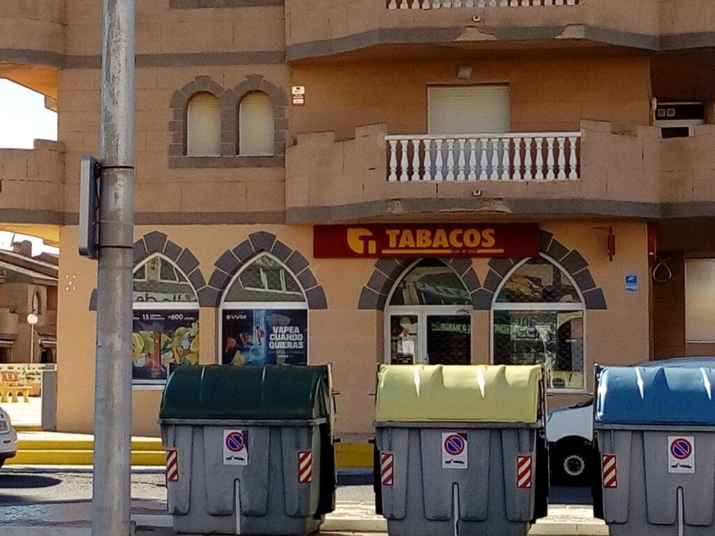 Fachada del Estanco Castillo de Mar Tabacos en La Manga del Mar Menor con rótulo amarillo y rojo en edificio con arcos
