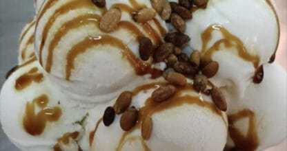 Cuenco de helado artesano de Fábrica Verdú con bolas blancas, salsa de caramelo y piñones tostados