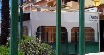 Exterior de Fashion La Manga visto desde pérgola con vegetación y cielo azul en La Manga del Mar Menor