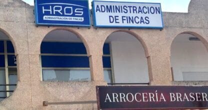 Rótulos de Fincas HRos Administración de Fincas en fachada de edificio en La Manga del Mar Menor junto a una arrocería