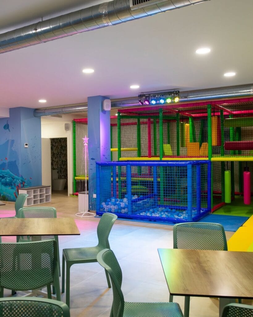 Interior de Flamenco Park La Manga con zona de juegos infantiles de colores y mesas para padres, La Manga del Mar Menor