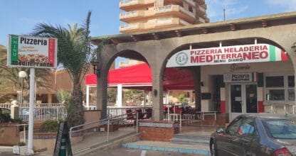 Barra de madera con grifos de cerveza, botellas y taburetes en Gelateria de La Manga del Mar Menor