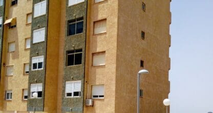 Fachada de edificio de apartamentos Hawaii 2 en La Manga del Mar Menor con acabado bicolor ocre y verde junto al litoral
