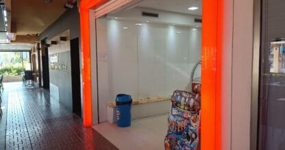 Local de heladería con entrada de neón naranja, mostrador acristalado y expositor de helados en La Manga del Mar Menor