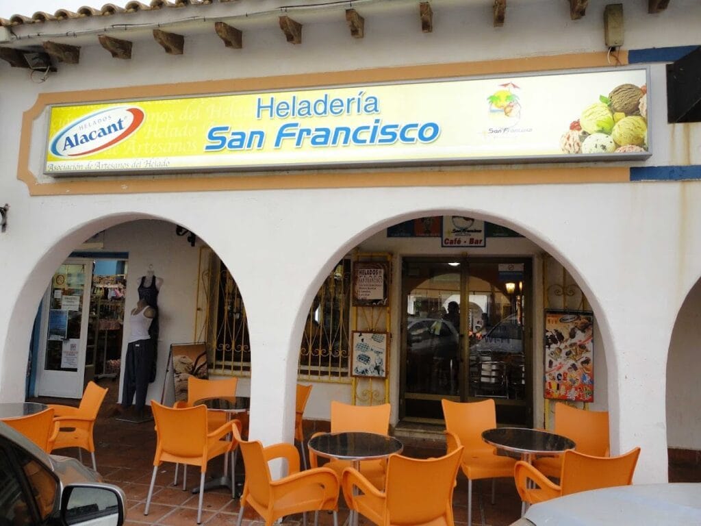 Fachada de la Heladería San Francisco con terraza de sillas naranjas y rótulo luminoso en La Manga del Mar Menor