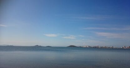 Vista panorámica del Mar Menor con aguas tranquilas, islas volcánicas al fondo y skyline de La Manga