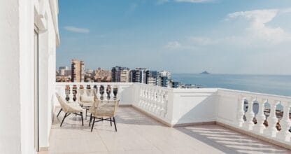 Terraza amplia del Hotel Delfines con sillas de ratán y vistas panorámicas al mar y skyline de La Manga del Mar Menor