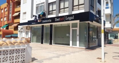 Local comercial de Iberbrit Legal Asesoría en esquina con gran cristalera y rótulo negro en La Manga del Mar Menor
